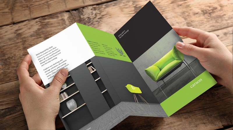 Green black brochure as a man holds in his hand